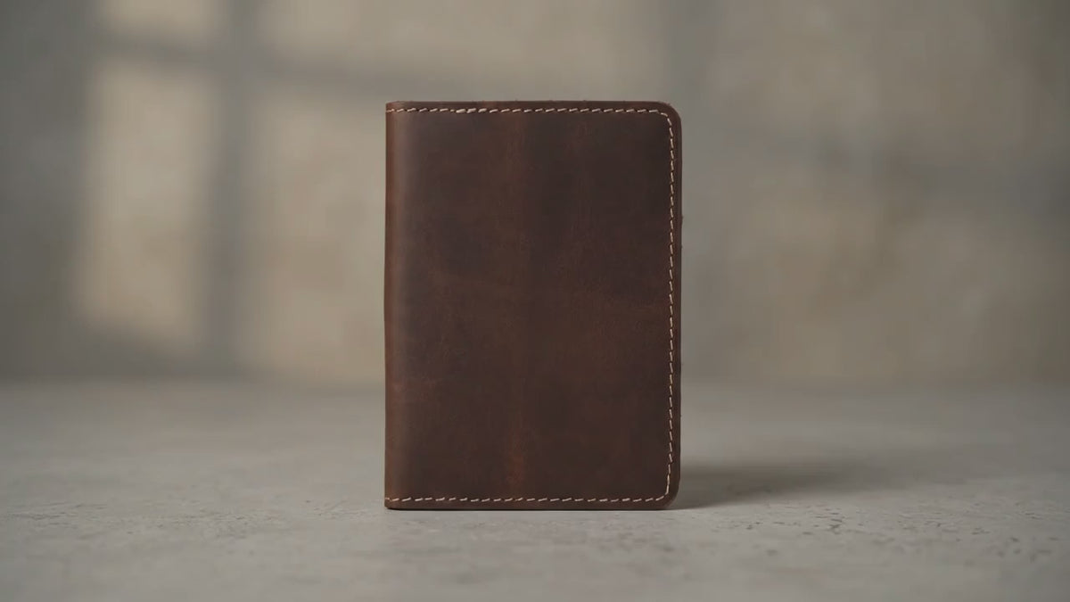 Load video: Handmade full-grain leather passport cover with card slots, shown open in rich brown leather.