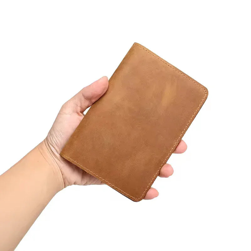 Hand holding a brown leather wallet against a white background